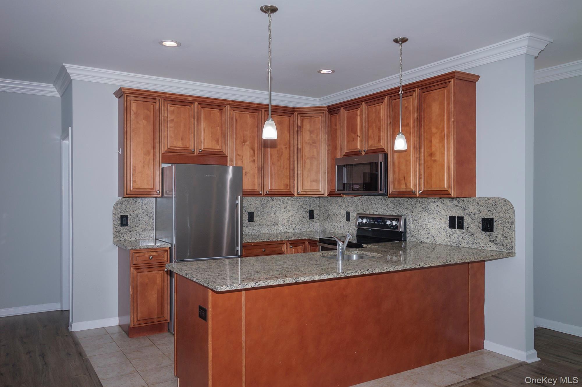115 Evergreen Street, Unit 106 West Babylon, NY 11704 - Photo 3 of 12 a kitchen with stainless steel appliances granite countertop a refrigerator a stove and a sink with wooden floor