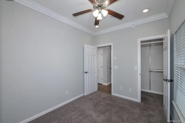 an empty room with closet and a chandelier fan