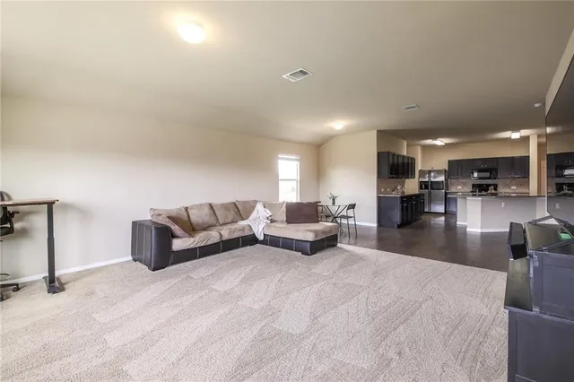 a living room with furniture and a dining table with kitchen view