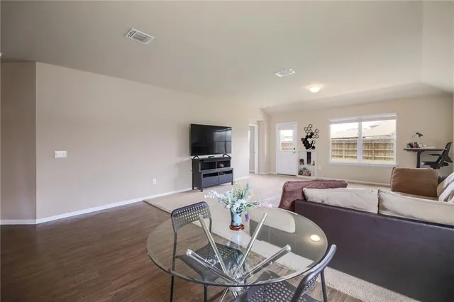 a living room with furniture a flat screen tv and a large window