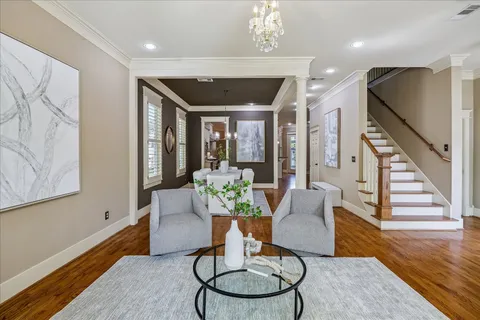 a living room with furniture a window and wooden floor