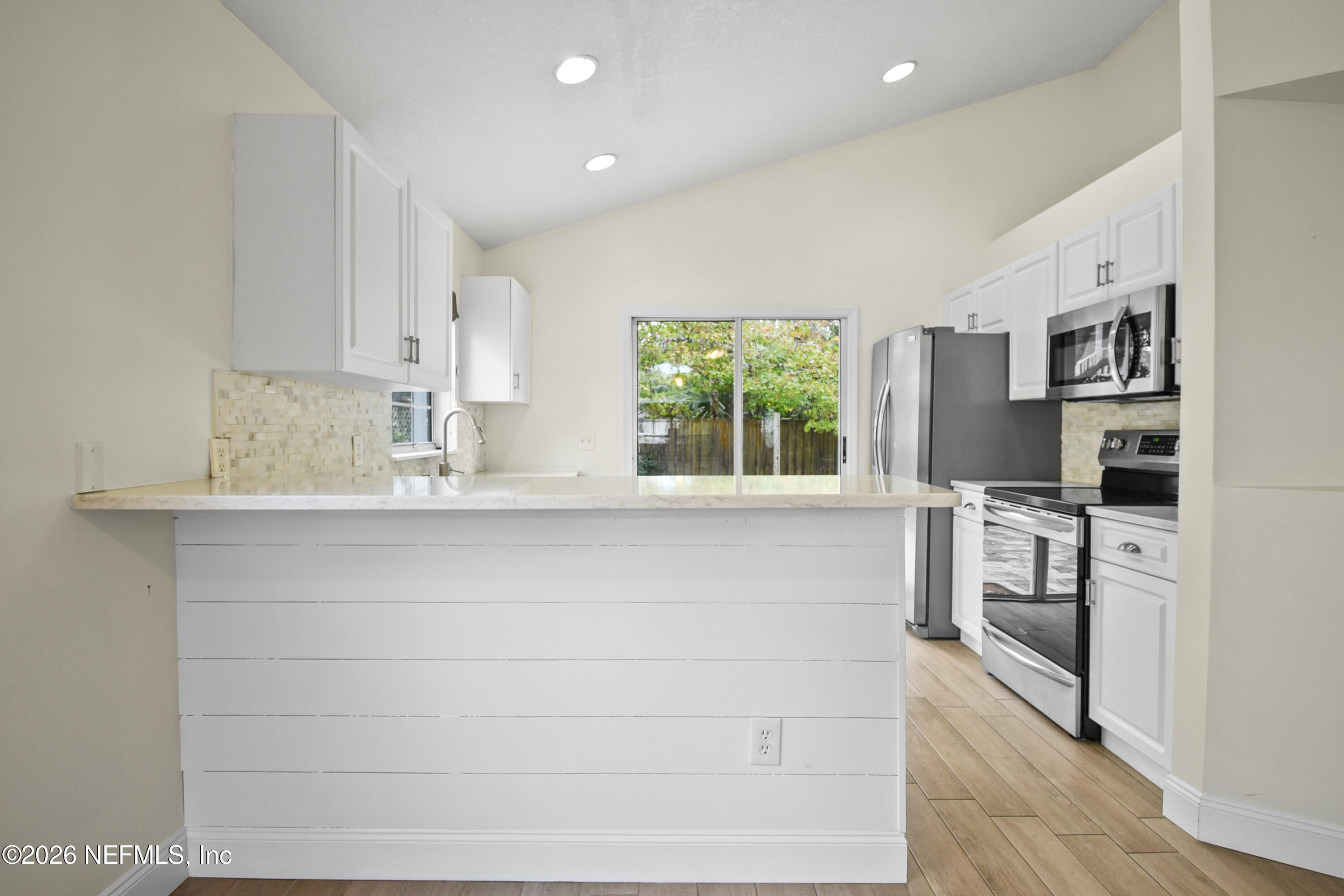 303 D Street St. Augustine Beach, FL 32080 - Photo 13 of 39 a kitchen with stainless steel appliances white cabinets and a window