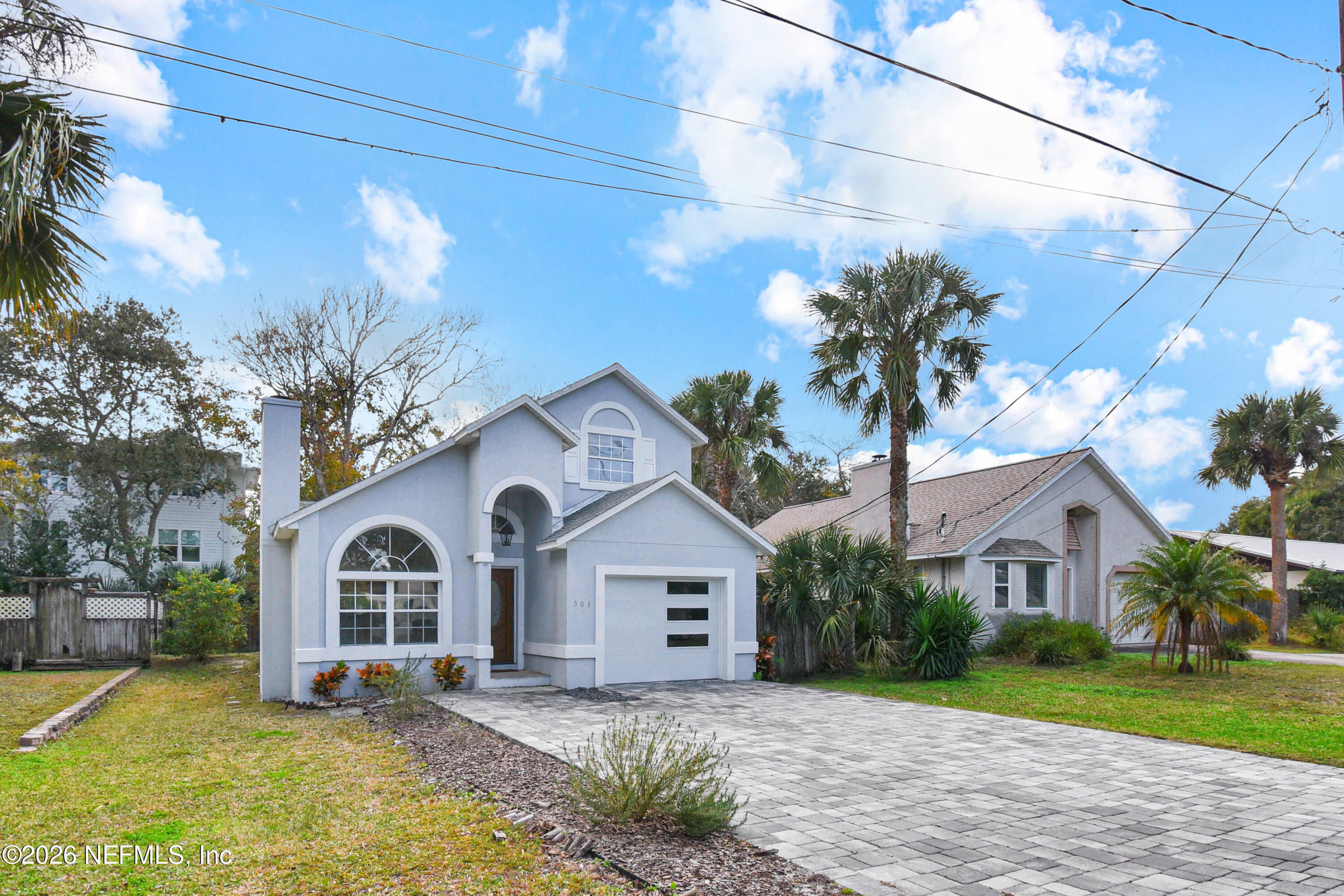 303 D Street St. Augustine Beach, FL 32080 - Photo 2 of 39 a view of a white house with a big yard and large trees
