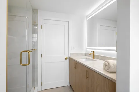 a bathroom with a granite countertop sink and a mirror