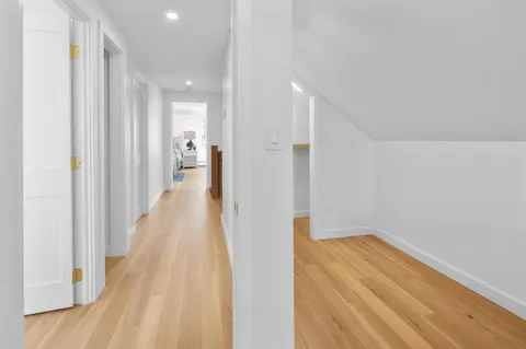 a view of a hallway with wooden floor
