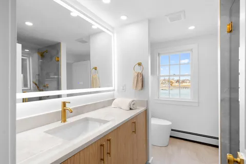 a bathroom with a sink and a mirror with toilet