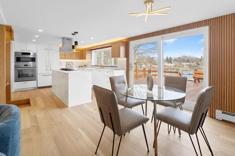 a dining room with furniture and a floor to ceiling window