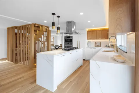 a very nice looking room with a large kitchen counter space and stainless steel appliances