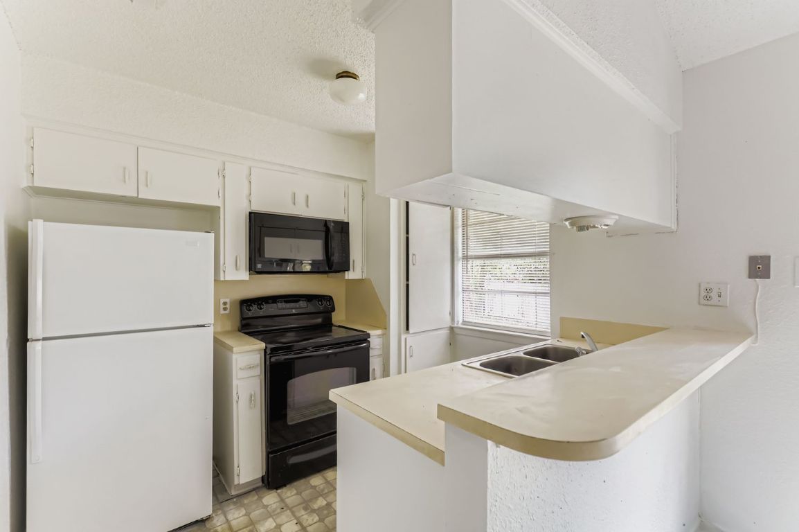 111 Stubblefield Drive Elgin, TX 78621 - Photo 5 of 27 a kitchen with a refrigerator and a stove top oven