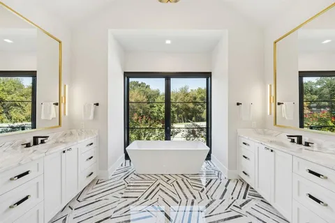 a spacious bathroom with a double vanity sink a mirror and a bathtub