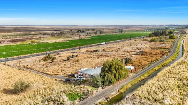 a front view of a house with a yard and lake view