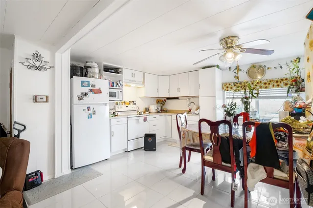 a kitchen with stainless steel appliances kitchen island a stove a sink dishwasher and white cabinets with wooden floor
