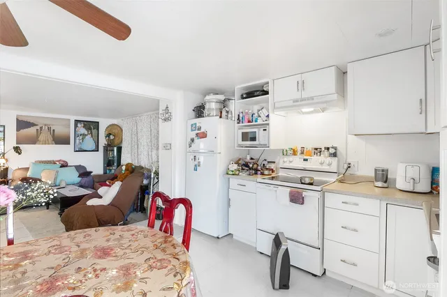 a view of a livingroom and a dining room with furniture chandelier and a window