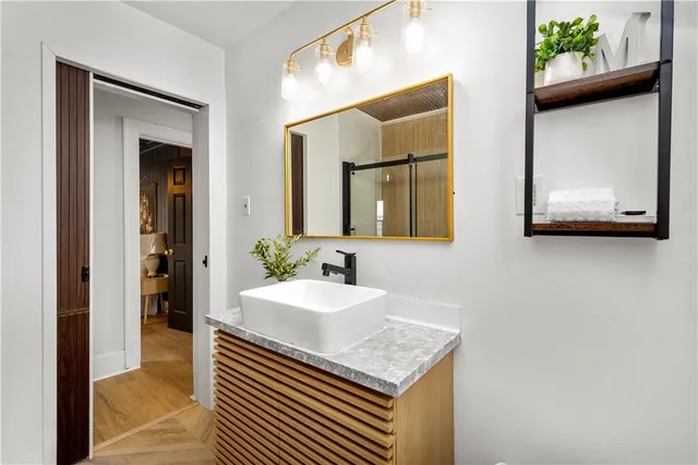 a bathroom with a granite countertop sink and a mirror