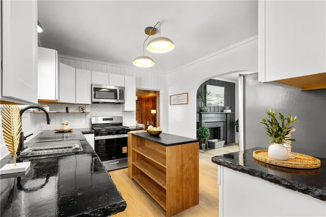a kitchen with granite countertop a sink stainless steel appliances and cabinets