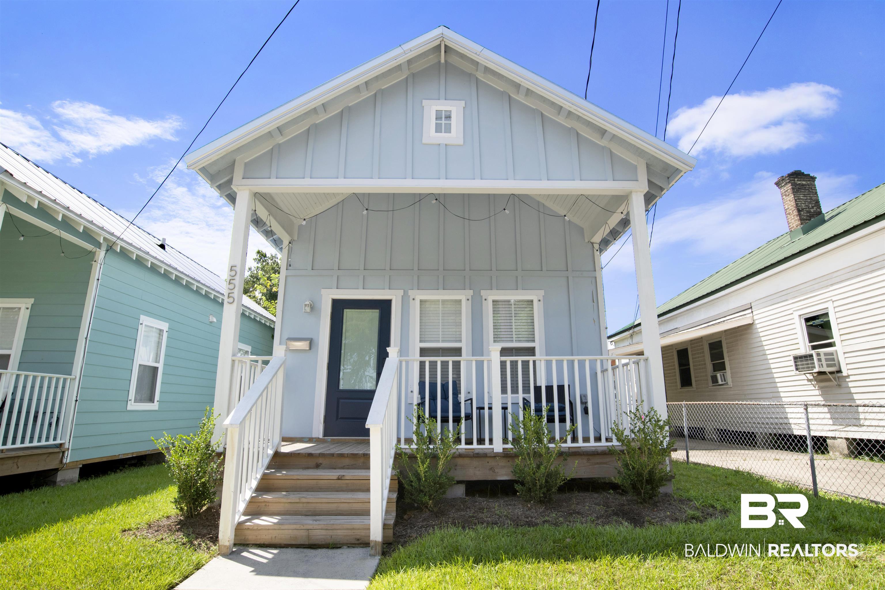 555 Congress Street Mobile, AL 36603 - Photo 3 of 27 View of front of property with board and batten siding, a front yard, and a wooden deck