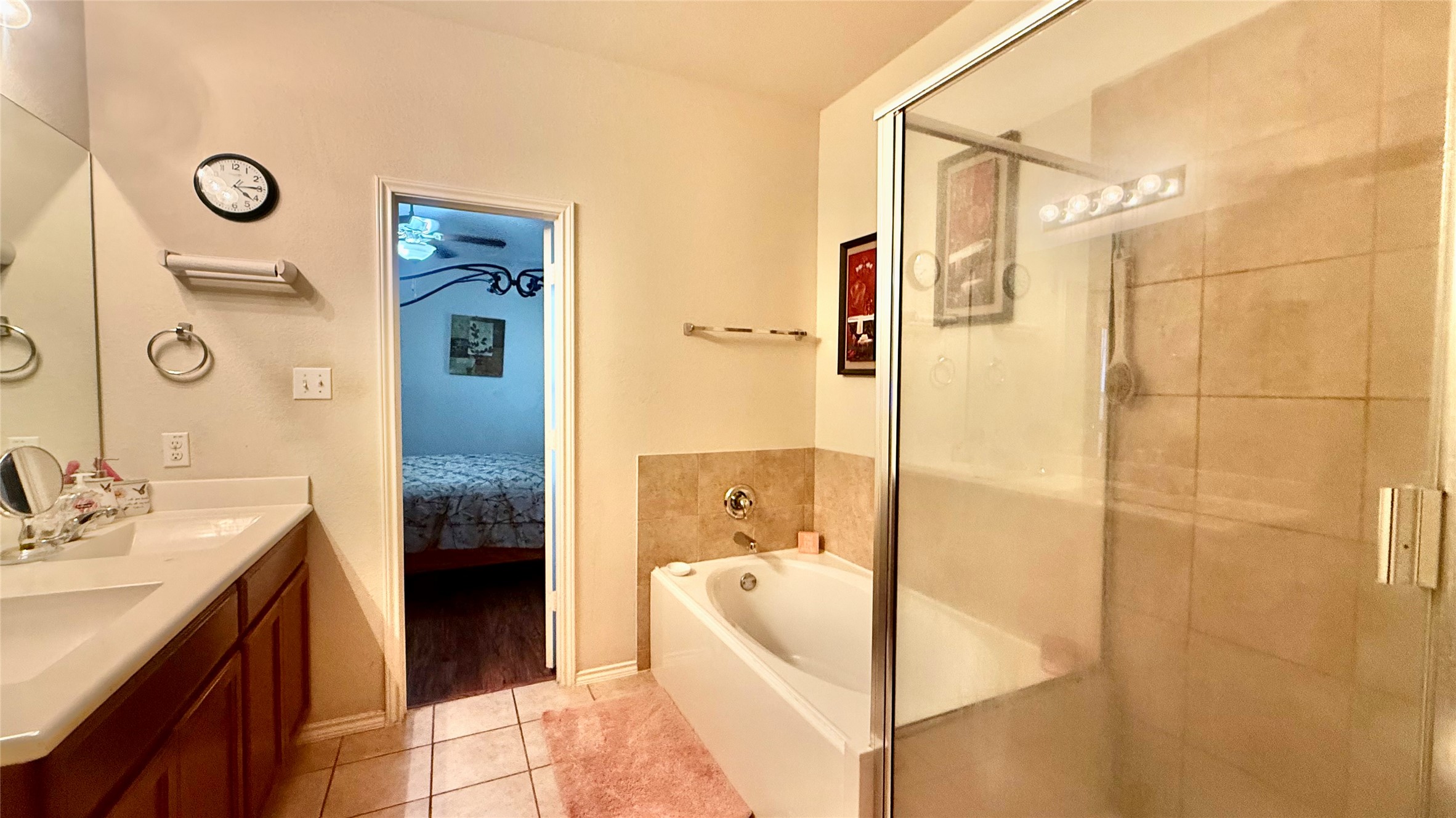 18309 Wind Tree Lane Elgin, TX 78621 - Photo 14 of 29 Tiled flooring and a glass-enclosed shower complement the integrated soaking tub setup.