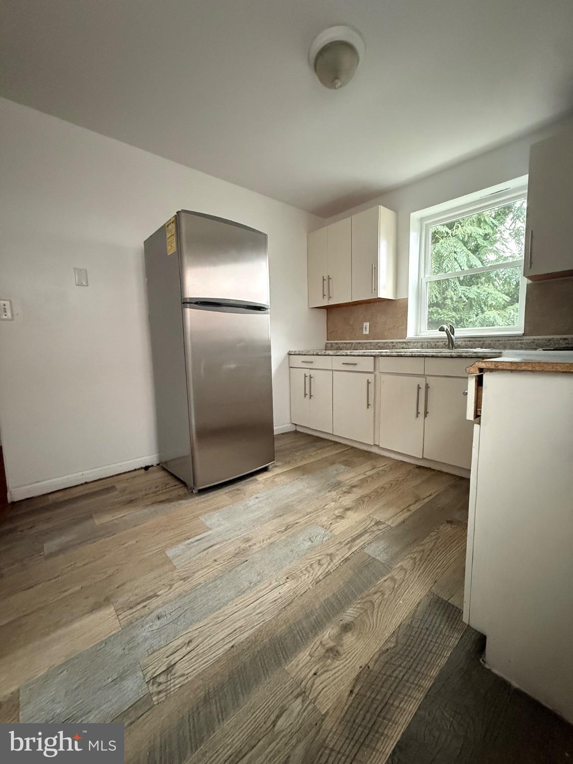 822 Wynnewood Road, Unit 2 Philadelphia, PA 19151 - Photo 13 of 15 a large white kitchen with a stove a sink dishwasher and a refrigerator