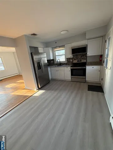 a kitchen with a refrigerator and a stove top oven