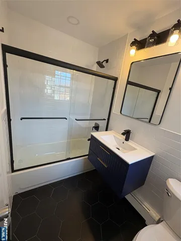 a bathroom with a sink and mirror with toilet