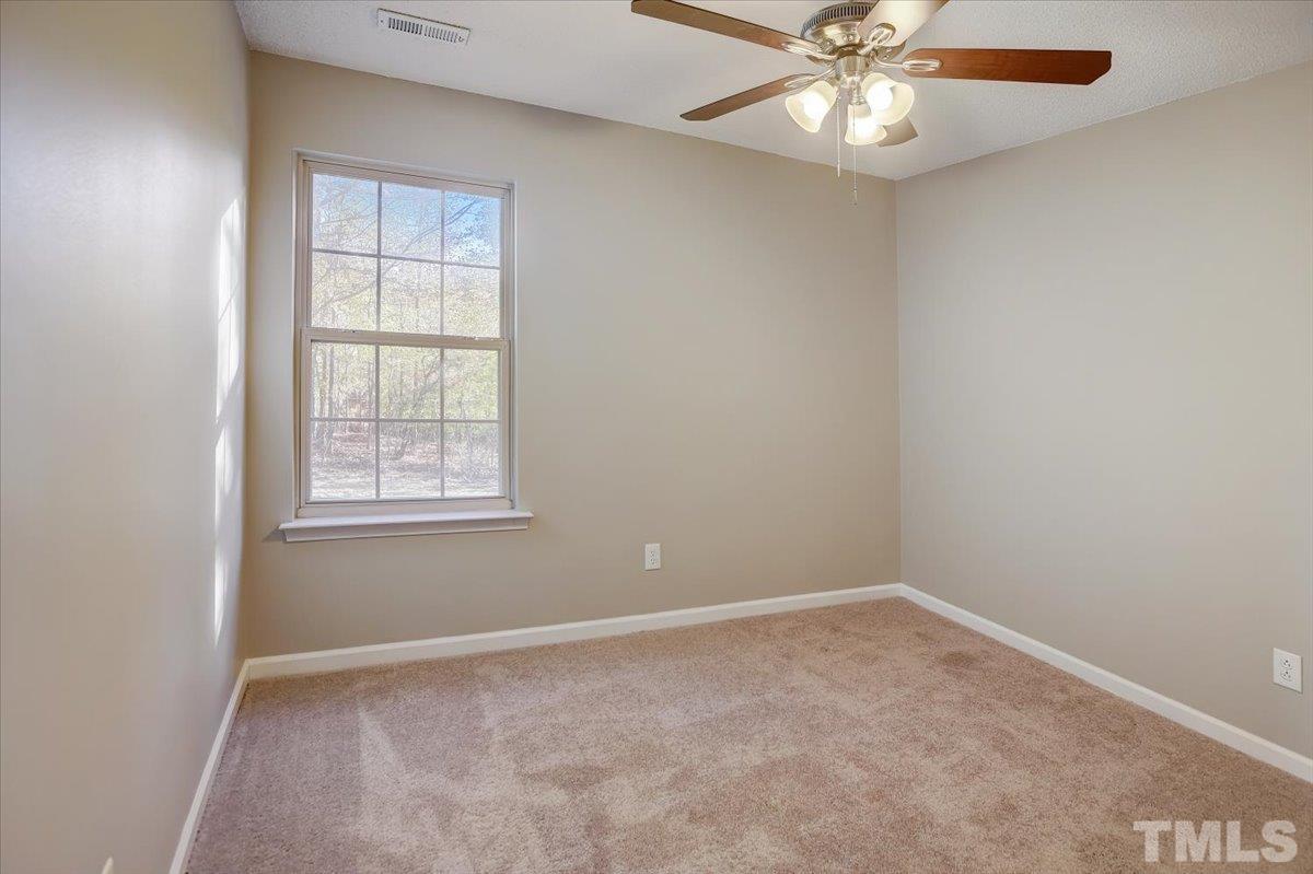 5102 Gable Ridge Drive Durham, NC 27713 - Photo 13 of 17 an empty room with a window and a fan