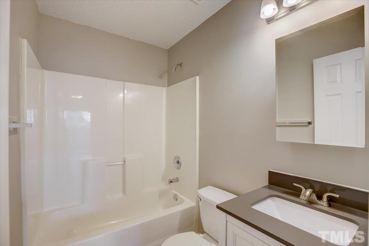 5102 Gable Ridge Drive Durham, NC 27713 - Photo 15 of 17 a bathroom with a sink a toilet and shower