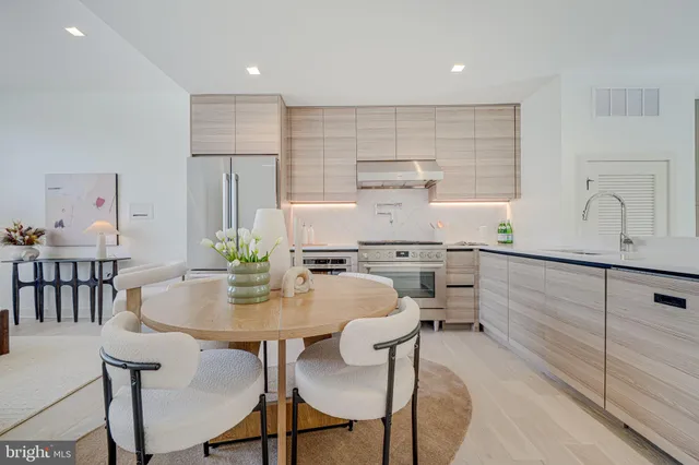 a kitchen with kitchen island a table and chairs in it