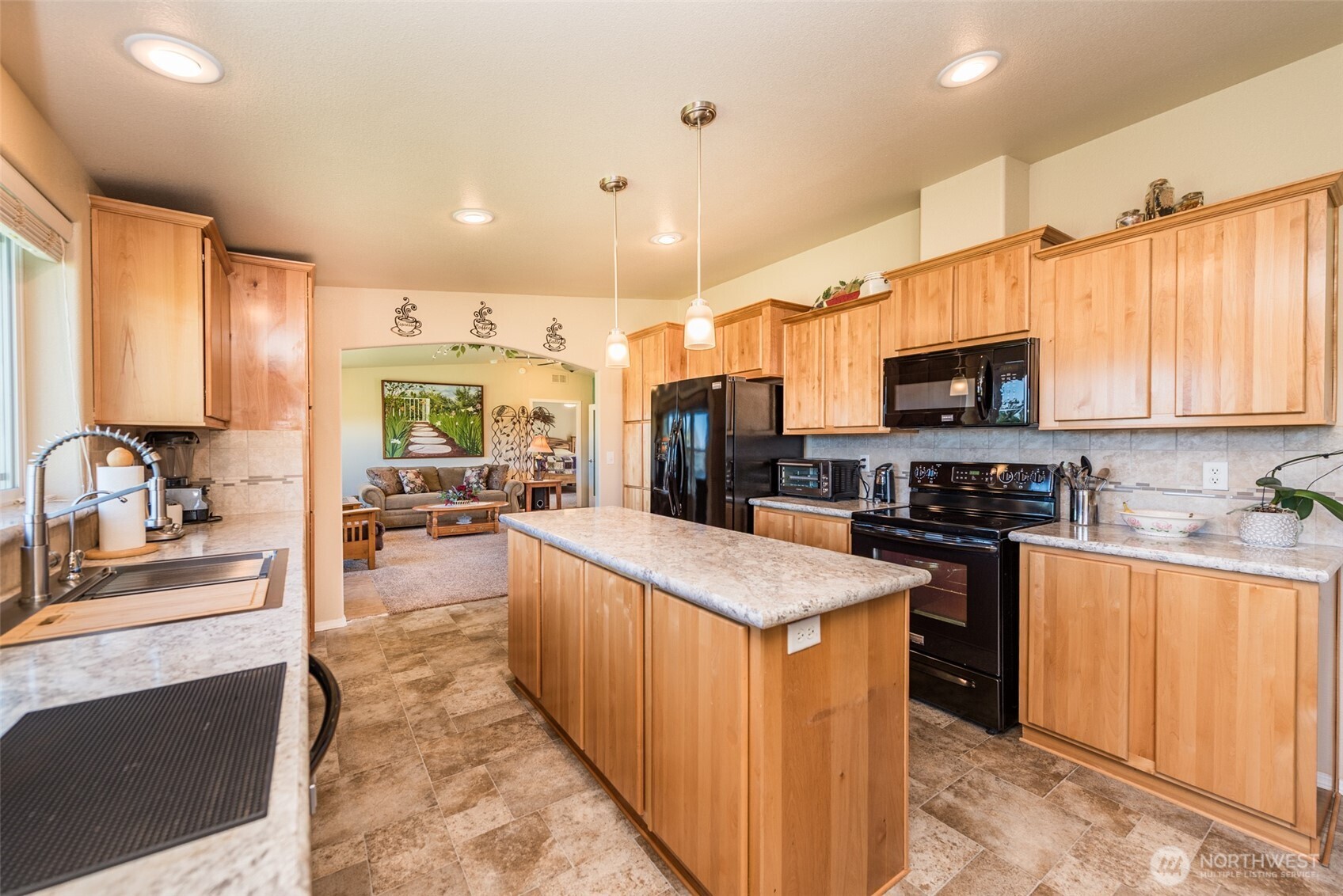 25 Michelle Lane Sequim, WA 98382 - Photo 20 of 38 a large kitchen with stainless steel appliances kitchen island granite countertop a stove top oven a sink dishwasher a dining table and chairs with wooden floor