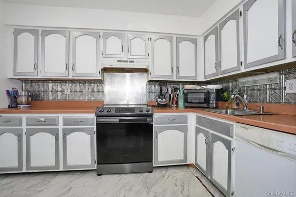 a kitchen with white cabinets and white appliances