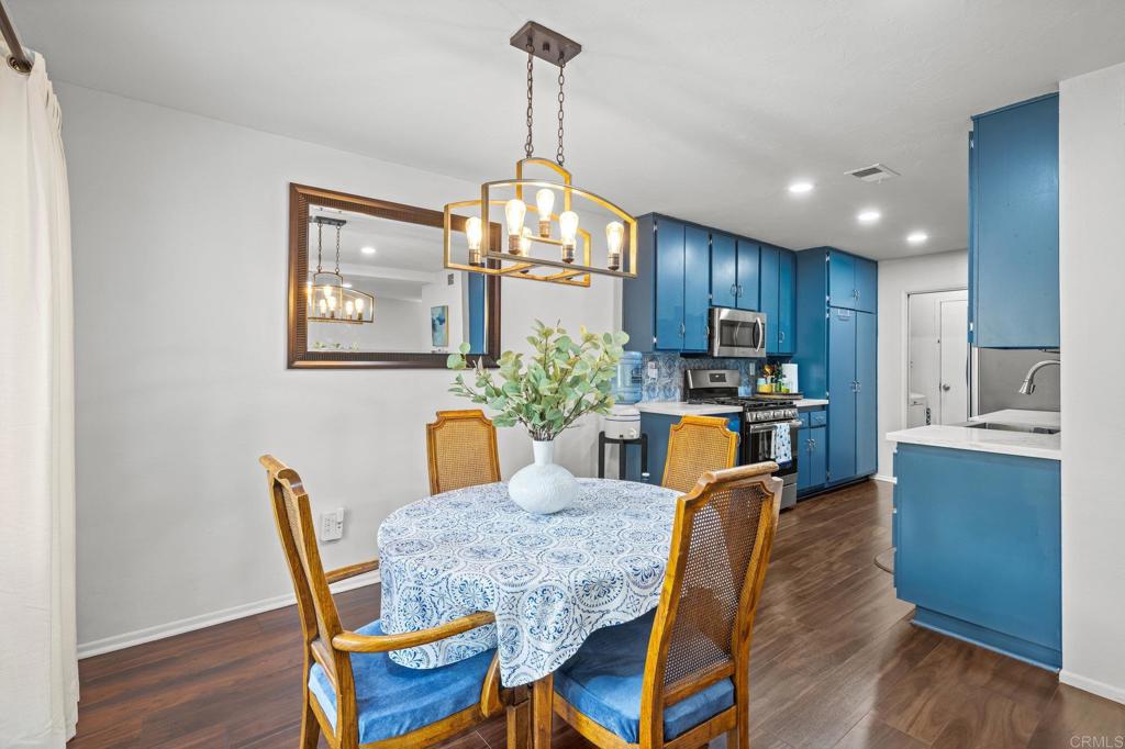4232 Fiesta Way, Unit 3 Oceanside, CA 92057 - Photo 11 of 33 a view of a dining room with furniture a chandelier and wooden floor