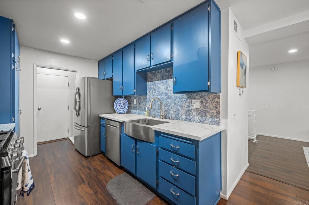 4232 Fiesta Way, Unit 3 Oceanside, CA 92057 - Photo 13 of 33 a kitchen with a refrigerator sink and wooden cabinets