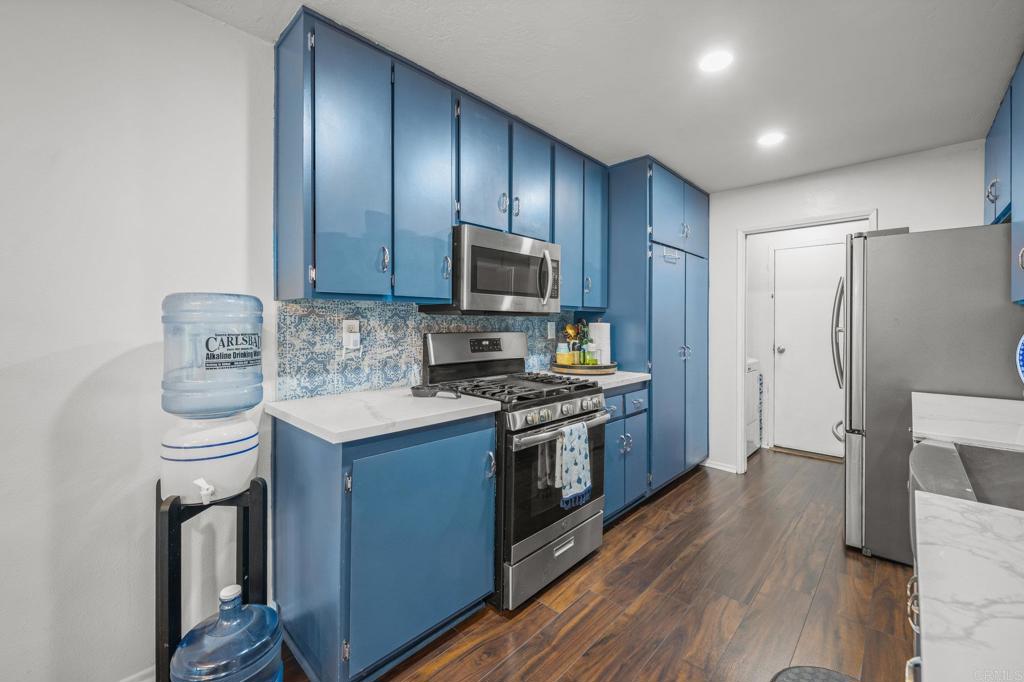 4232 Fiesta Way, Unit 3 Oceanside, CA 92057 - Photo 14 of 33 a kitchen with stainless steel appliances wooden cabinets and a stove top oven