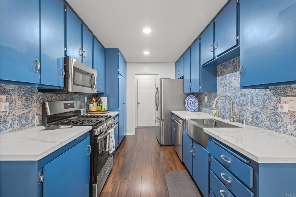 4232 Fiesta Way, Unit 3 Oceanside, CA 92057 - Photo 9 of 33 a kitchen with stainless steel appliances granite countertop wooden cabinets sink stove and refrigerator