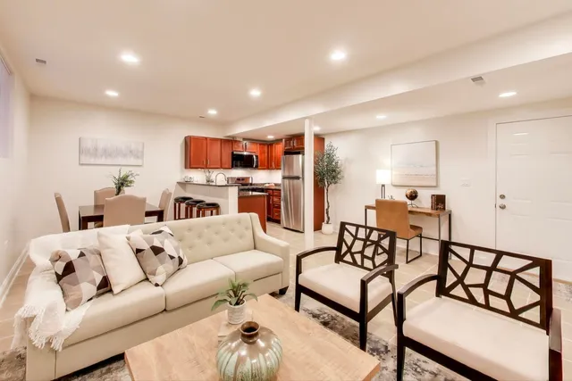 a living room with furniture and a dining table with kitchen view