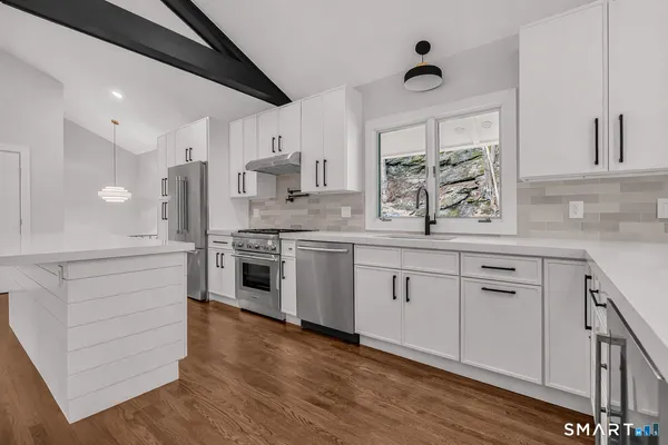a kitchen with white cabinets stainless steel appliances and sink