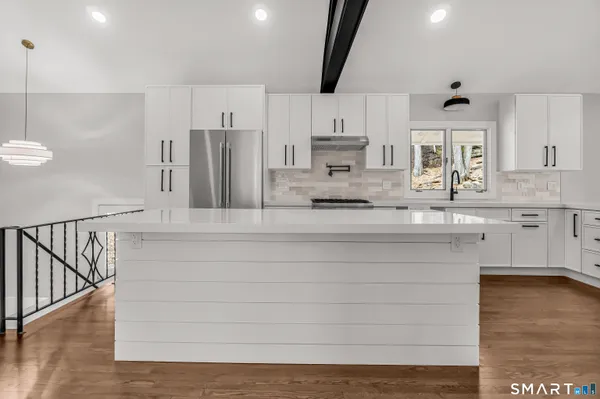 a kitchen with kitchen island a sink stainless steel appliances and cabinets