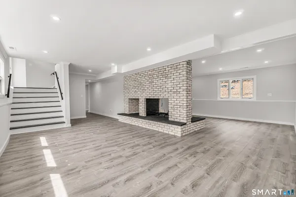 an empty room with wooden floor and fireplace