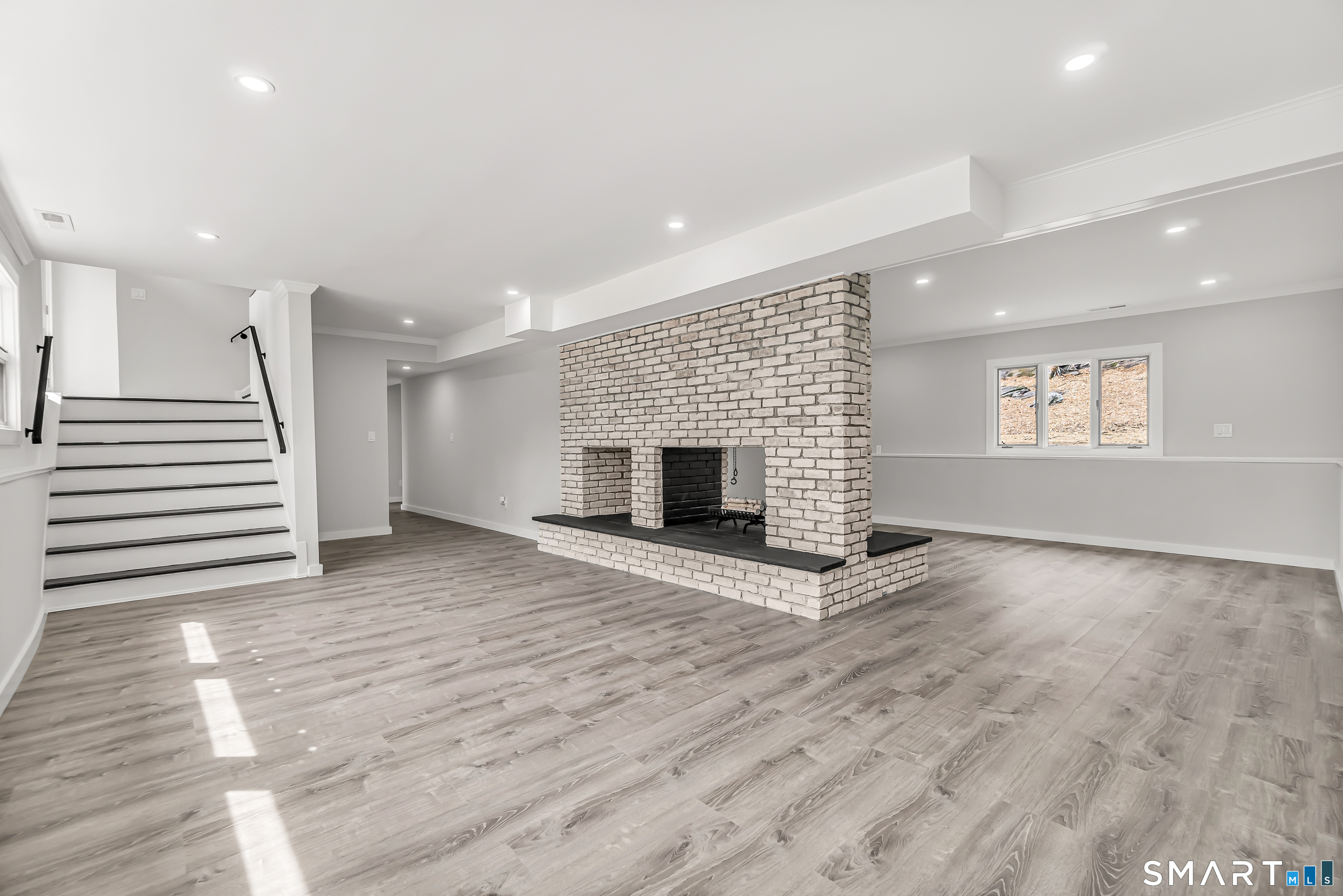 73 Buck Hill Road Easton, CT 06612 - Photo 29 of 44 an empty room with wooden floor and fireplace