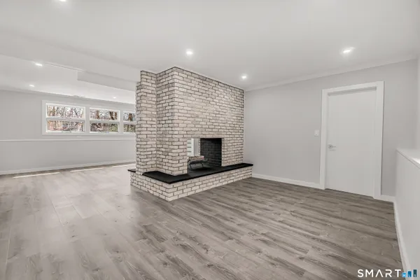 a view of empty room with wooden floor and fireplace