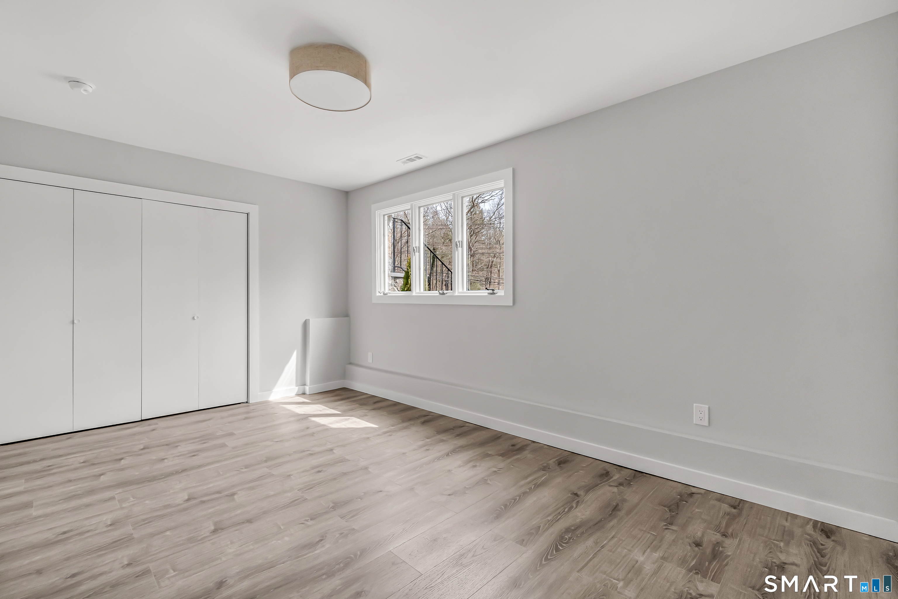 73 Buck Hill Road Easton, CT 06612 - Photo 31 of 44 an empty room with wooden floor and windows