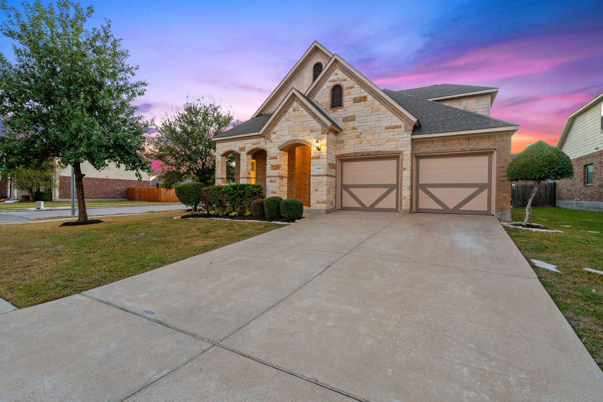 21100 Windmill Ranch Avenue Pflugerville, TX 78660 - Photo 22 of 29 French country home featuring concrete driveway, stone siding, roof with shingles, an attached garage, and brick siding
