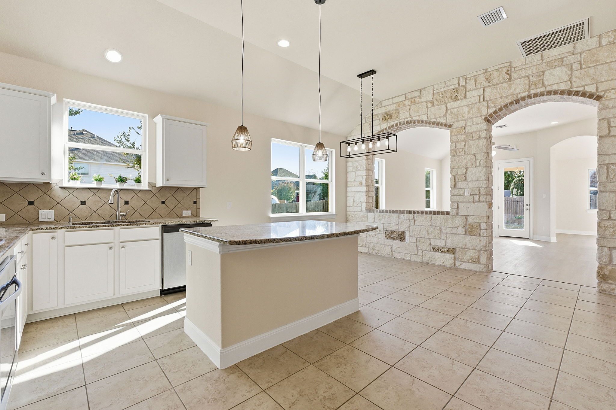 21100 Windmill Ranch Avenue Pflugerville, TX 78660 - Photo 8 of 29 Kitchen featuring arched walkways, hanging light fixtures, white cabinets, light tile patterned floors, and stainless steel appliances