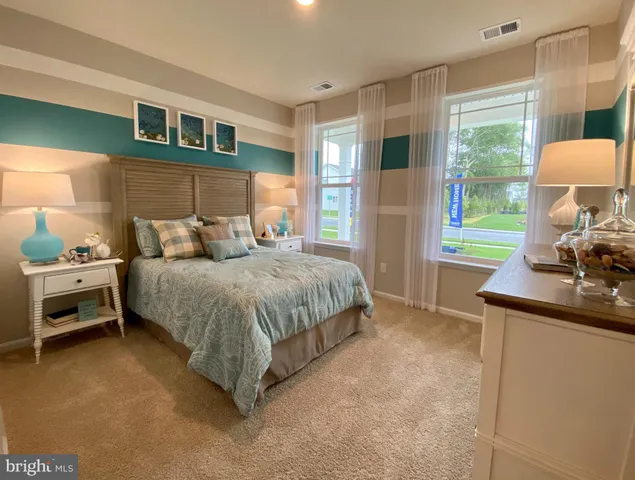 a bedroom with a bed and a dresser next to a window