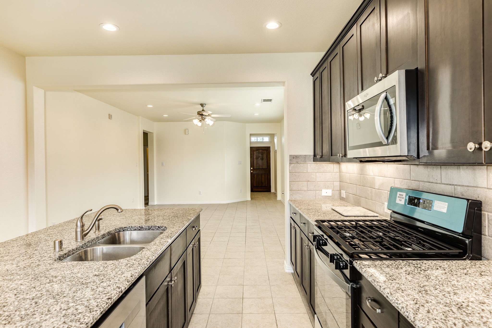 1301 Scarlet Mountain Drive Rosharon, TX 77583 - Photo 43 of 43 a kitchen with stainless steel appliances granite countertop a sink and stove top oven with wooden floor