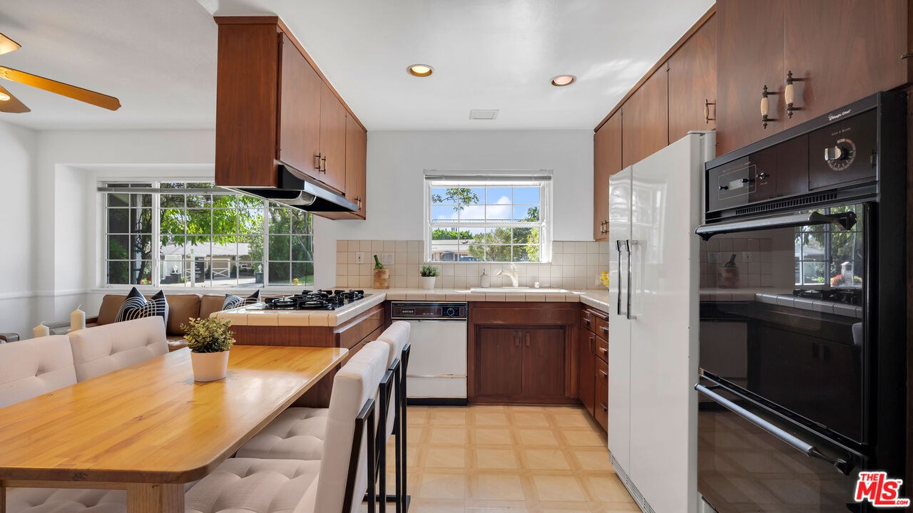 18501 Germain Street Porter Ranch, CA 91326 - Photo 19 of 55 a kitchen with stainless steel appliances granite countertop a sink and a refrigerator