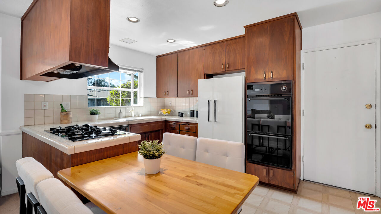 18501 Germain Street Porter Ranch, CA 91326 - Photo 20 of 55 a kitchen with stainless steel appliances a stove a refrigerator and a dining table