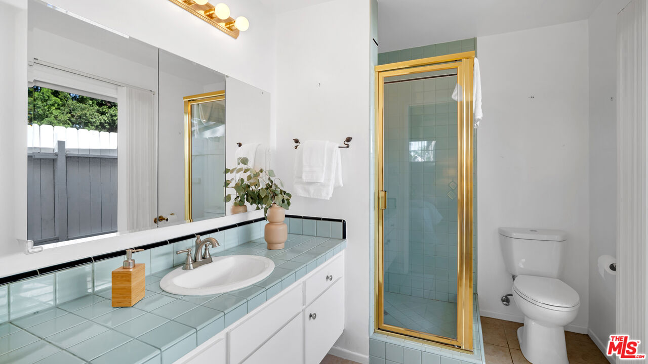 18501 Germain Street Porter Ranch, CA 91326 - Photo 30 of 55 a bathroom with a granite countertop sink and a mirror with toilet