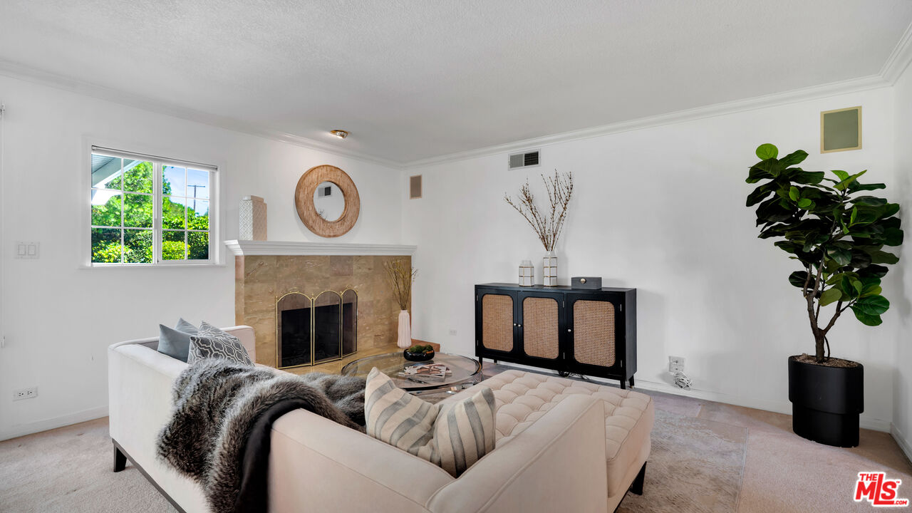 18501 Germain Street Porter Ranch, CA 91326 - Photo 7 of 55 a living room with furniture a potted plant and a fireplace