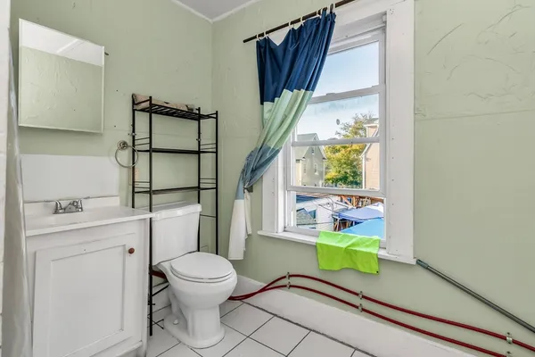 a bathroom with a toilet a sink and a window