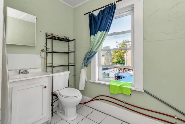 a bathroom with a toilet a sink and a window